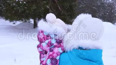 在寒冷的冬日，妈妈和小宝宝在针叶林公园里沿着下雪的冬天的散步。 一家人带着小孩散步